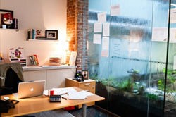 Water runs down a glass wall, which doubles as a dry erase board, in the Cactus Building located in the Central Platte Valley of Denver.